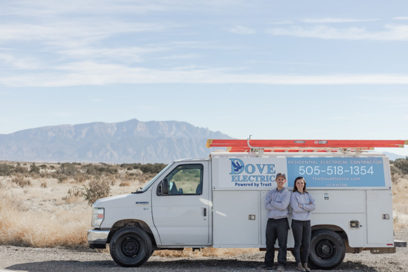 Dove Electric van with two electricians in Albuquerque smiling