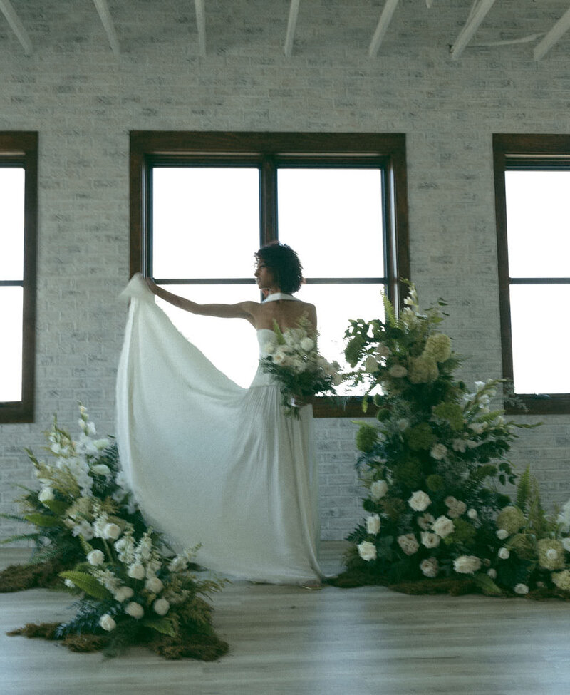 A person holding out one side of their wedding dress.