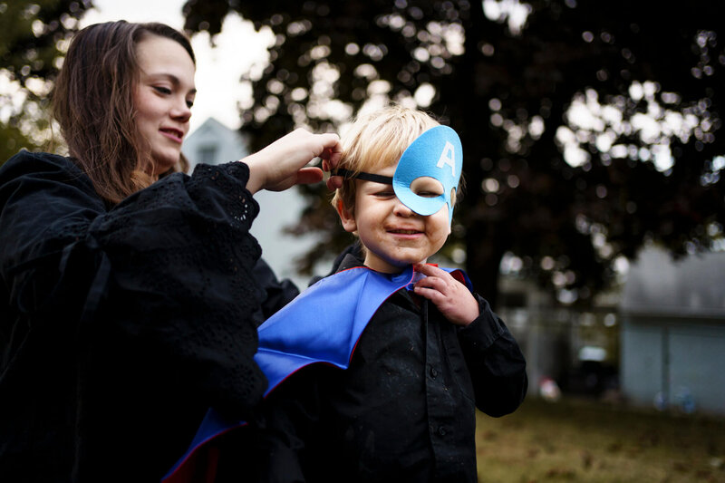 DOCUMENTARY-FAMILY-PHOTOGRAPHY-LA CROSSE-WISCONSIN - MOM HELPING SON PUT SUPER HERO MASK ON