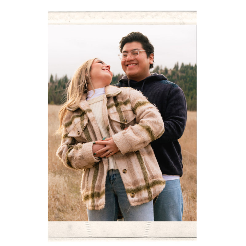 Couple dreamily and lovingly look into each others eyes in a golden field.