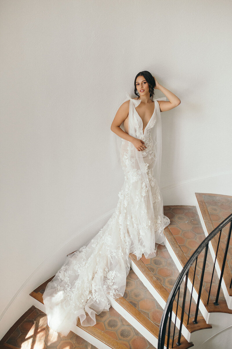 Woman on the stairs in her wedding dress posing for photographer