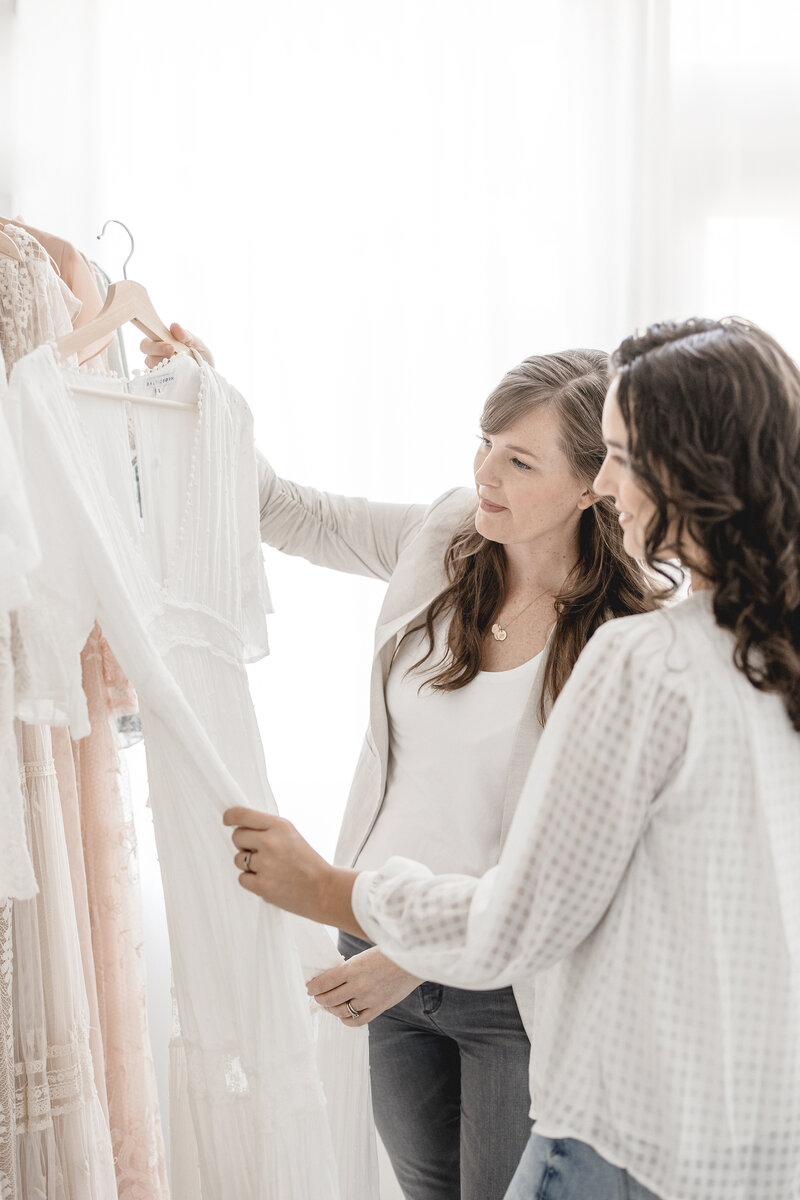 two women looking at dresses for session