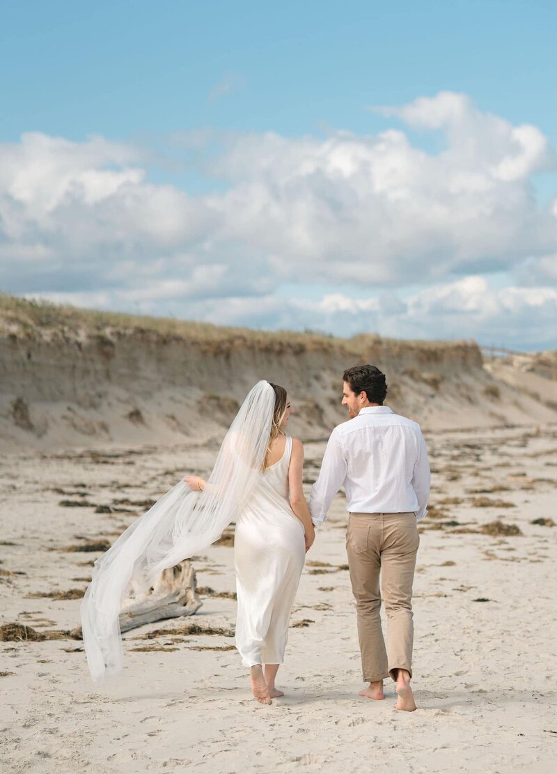Maine Couple walking the beach after their wedding ceremony