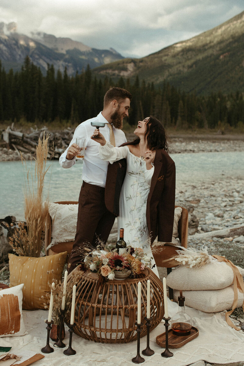 bride and groom toasting to elopement in mountains of Alberta