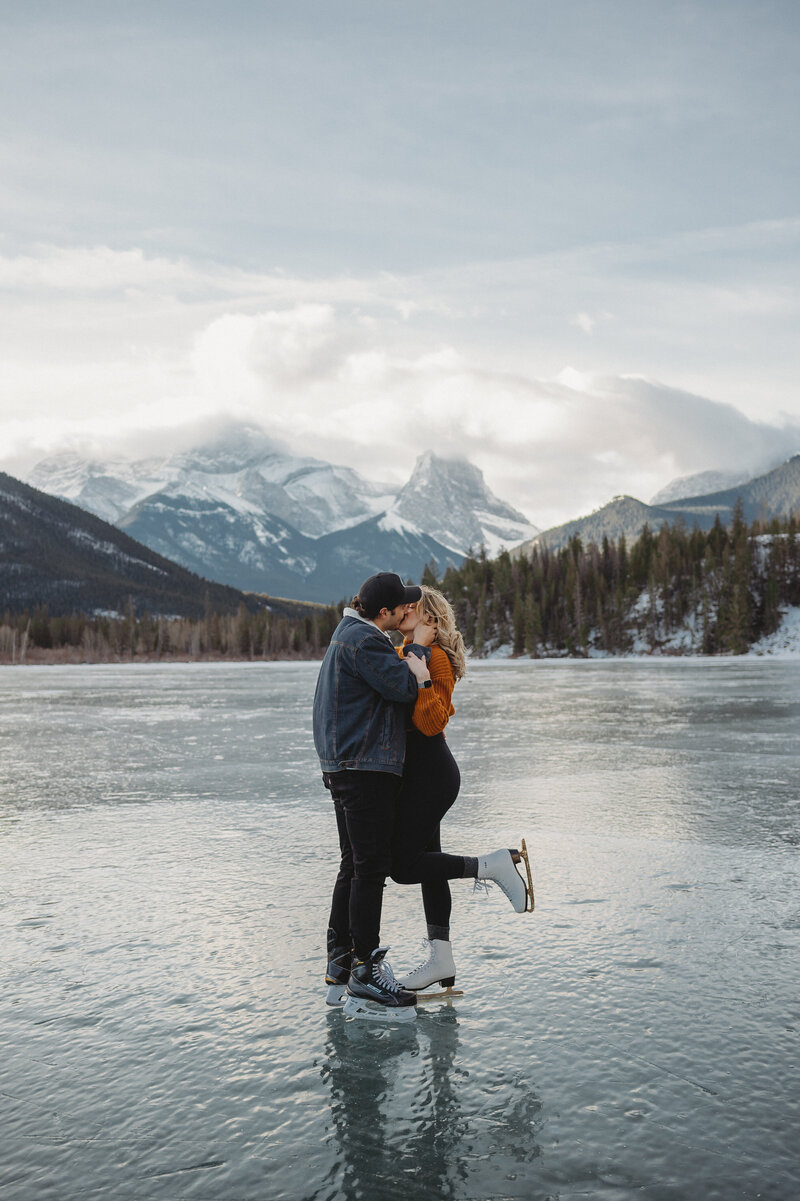 Engaged couple skating on a lake in the Alberta Rocky Mountains