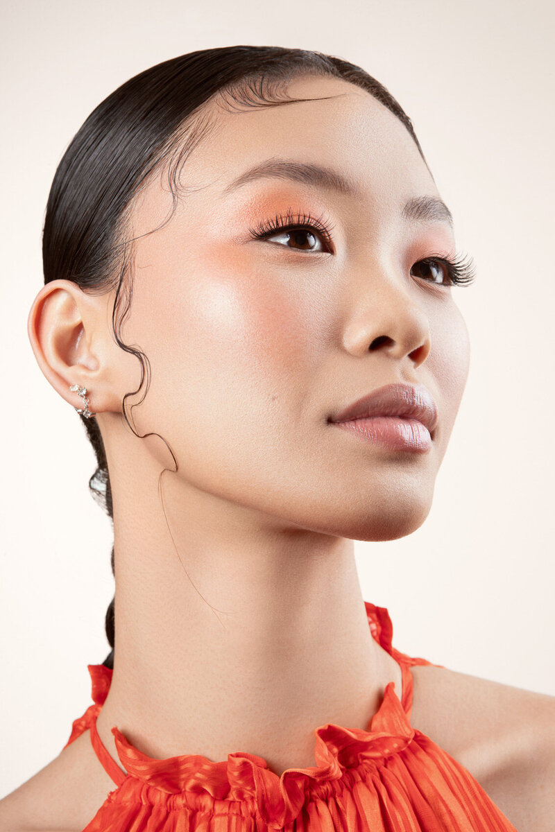 Jiaqi in a minimalist beauty portrait, showcasing smooth skin and sleek styling, captured by Ylva Erevall.