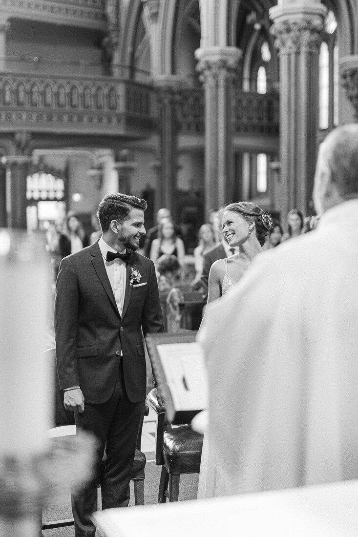 The bride and groom share a look of complicity during their church wedding ceremony.