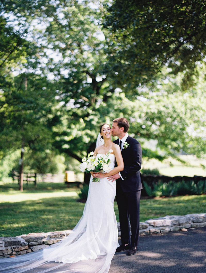 Couple share a sweet moment under the trees at their first look at Goodstone Inn