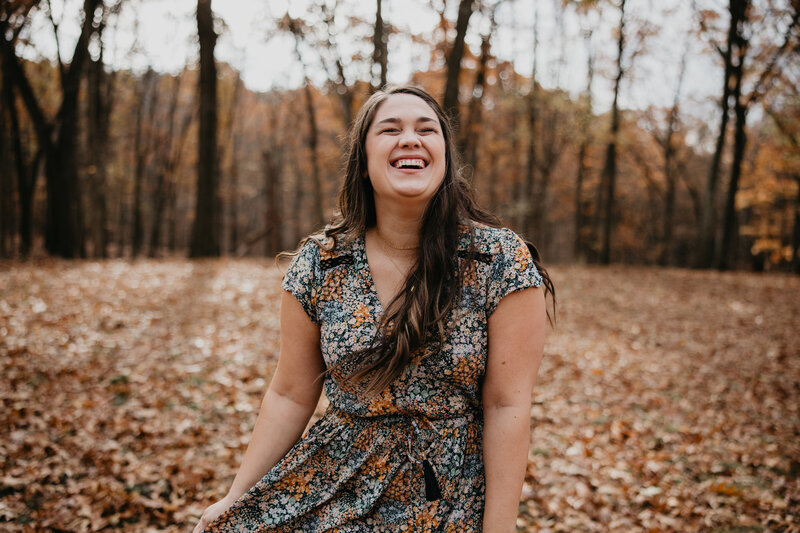 Photo of Kaitlin Powell Photography laughing in the forest. Photo taken by Rachel Rowland.