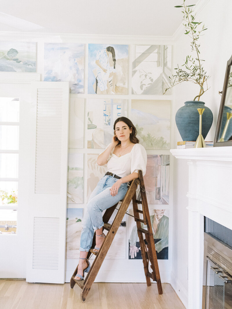 An interior designer recline on her antique step ladder as she confidently looks surveys her design. | Pittsburgh Brand Photographer | Michi Interiors | Anna Laero Photography
