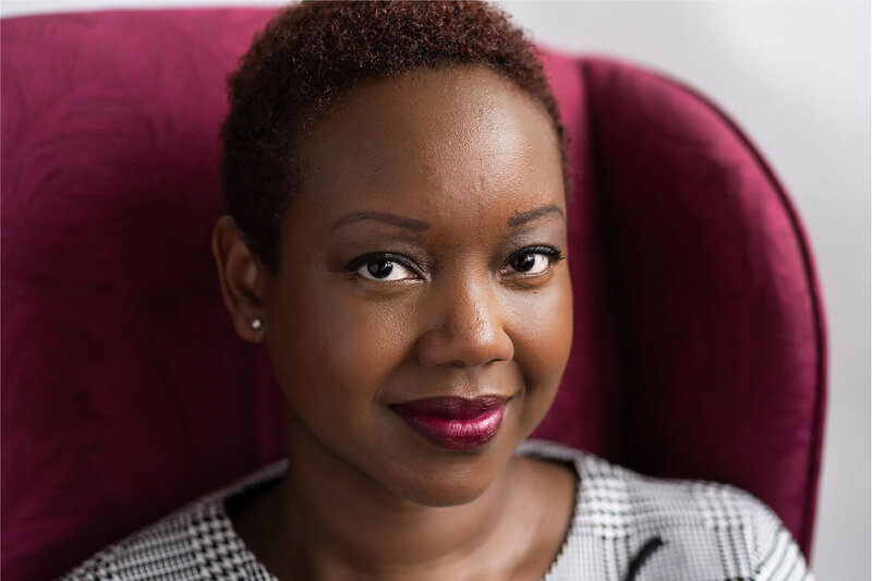 professional woman smiling in fuchsia chair