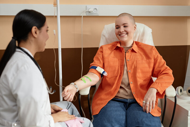 smiling-bald-woman-talking-to-nurse-2024-02-27-21-03-27-utc