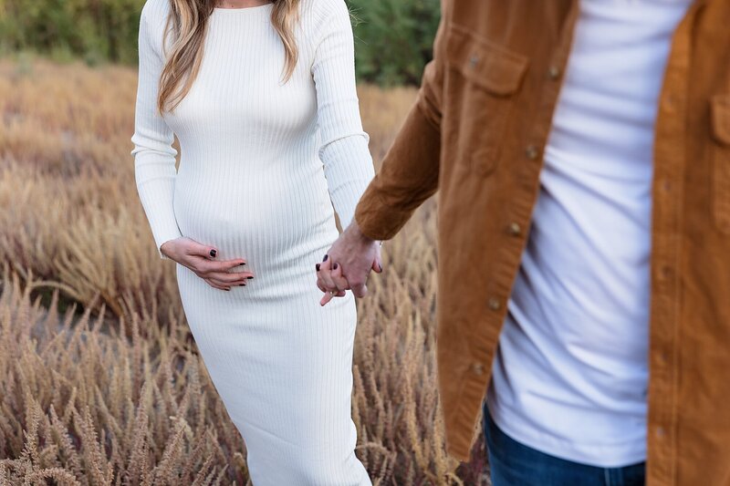 pregnant woman holding her husband's hand