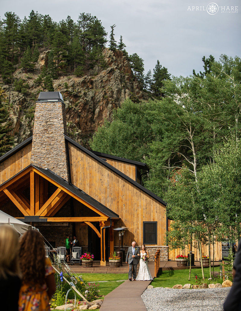 Bride and father walk down the aisle at Blackstone Rivers Ranch