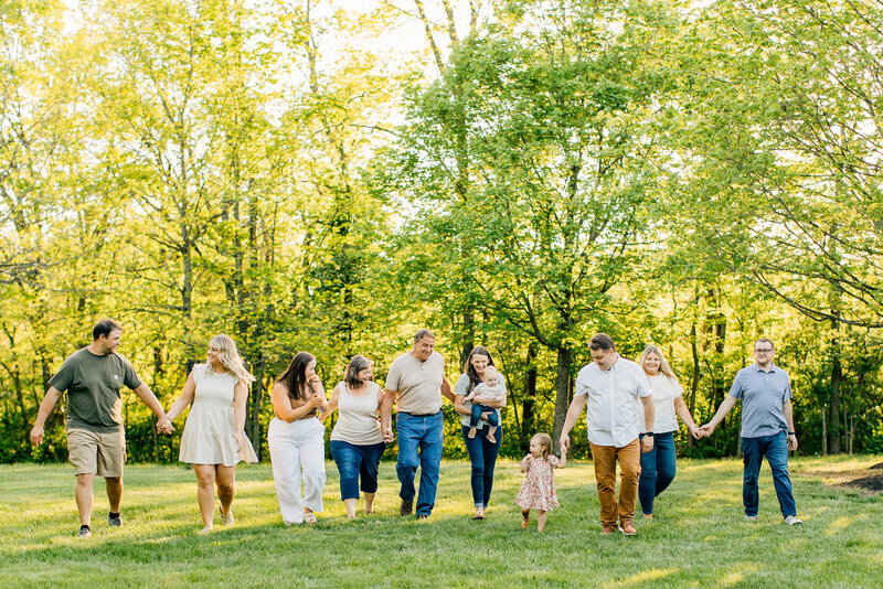 Family standing in a field holding hands