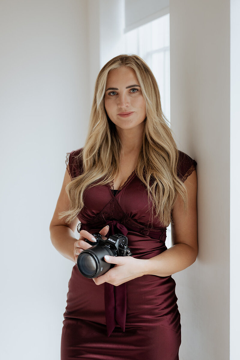 utah wedding photographer by becca poses with camera