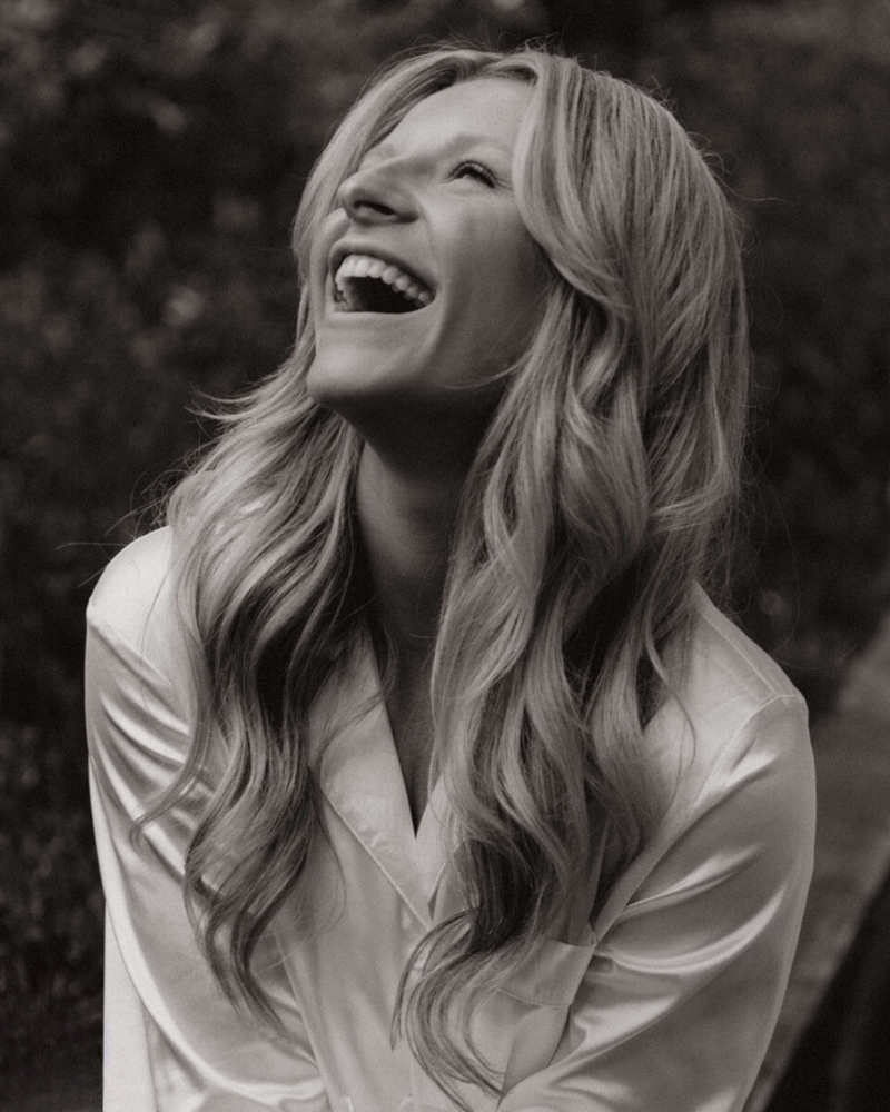 Cynthia Calderon laughs joyfully in a black-and-white portrait, showcasing her warm and creative spirit.