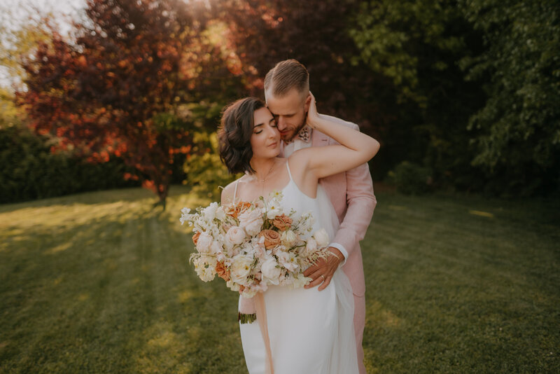 Brautpaar mit Brautstrauß im Garten von Aiola im Schloss St. Veit – stilvolle Hochzeit in der Steiermark