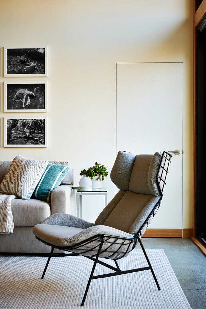 Boston interior designer creates a Hingham pool house living room with a contemporary lounge chair and sleek, modern coastal-inspired design.