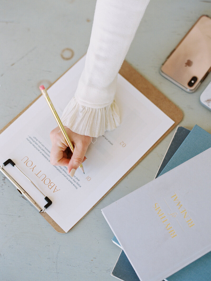 woman writing notes on a clipboard