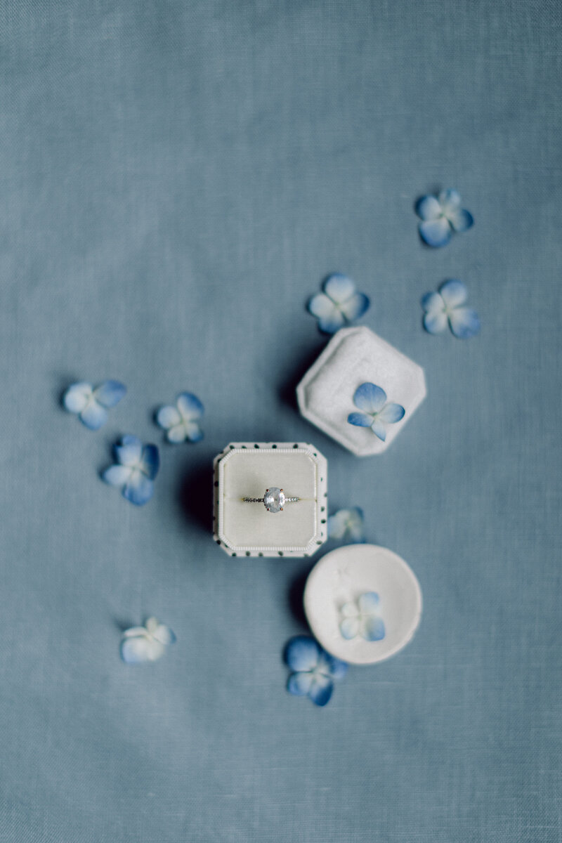 Soft blue linen flat lay mat styled with romantic paper goods and silk ribbon
