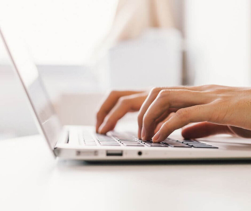 woman's hands typing on keyboard