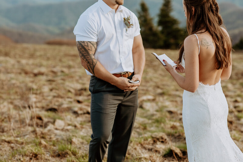 photo of bride reading her vows on a mountaintop during their Asheville elopement