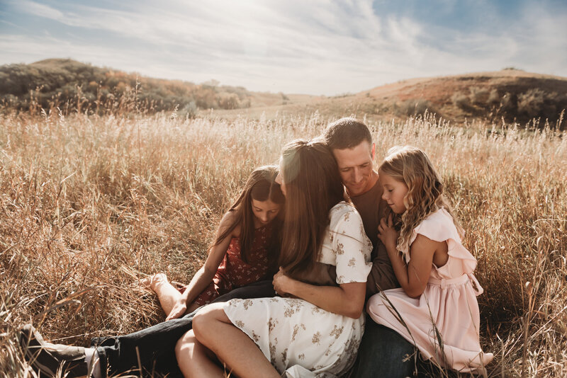 A family snuggles in together and holds tight to a tender moment along the banks of Harmon Lake north of Mandan, ND. 
