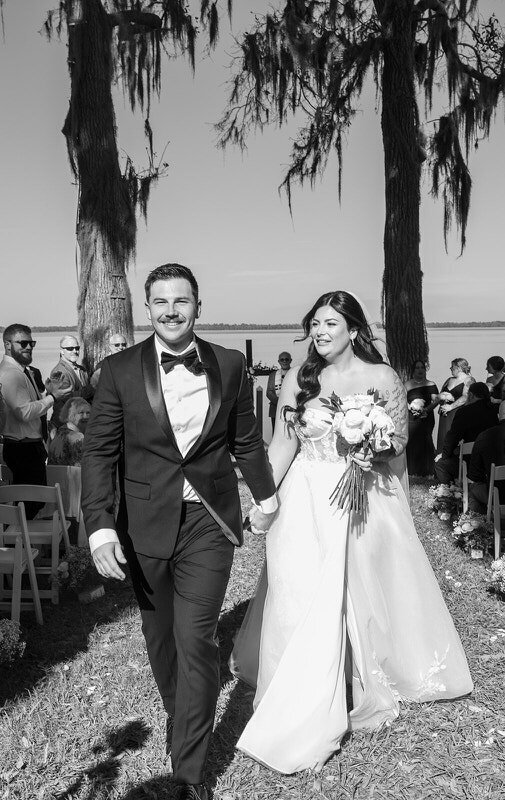 Black and white shot of bride and groom walking down the aisle at a Palm Coast wedding