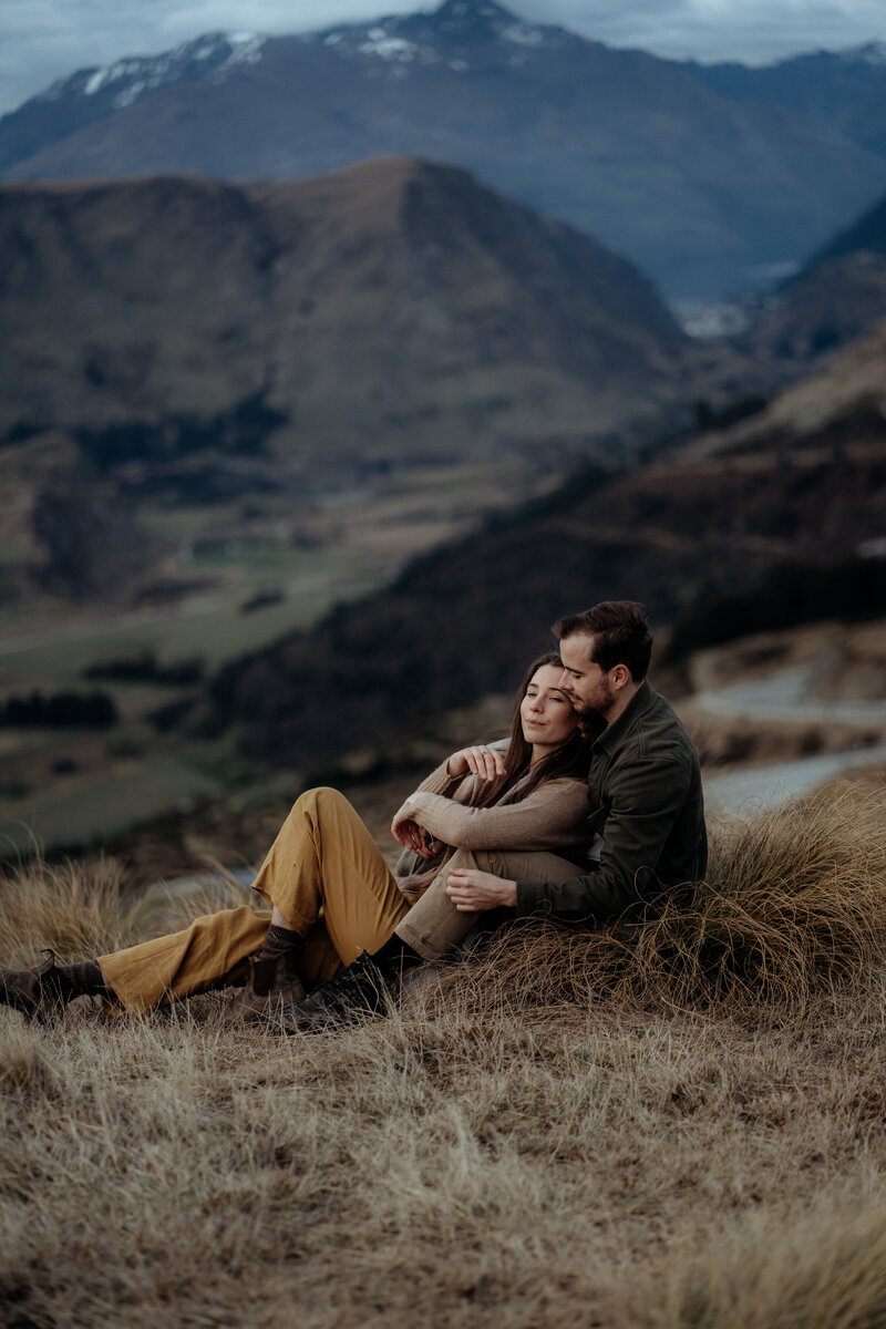 couple embracing on the mountain during auckland engagement shoot
