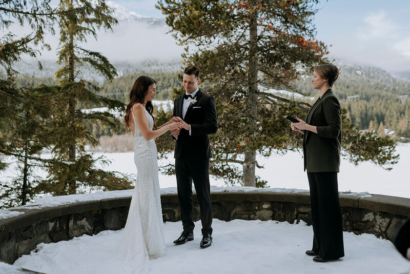 Whistler groom bends down to pet dog after Whistler wedding ceremony