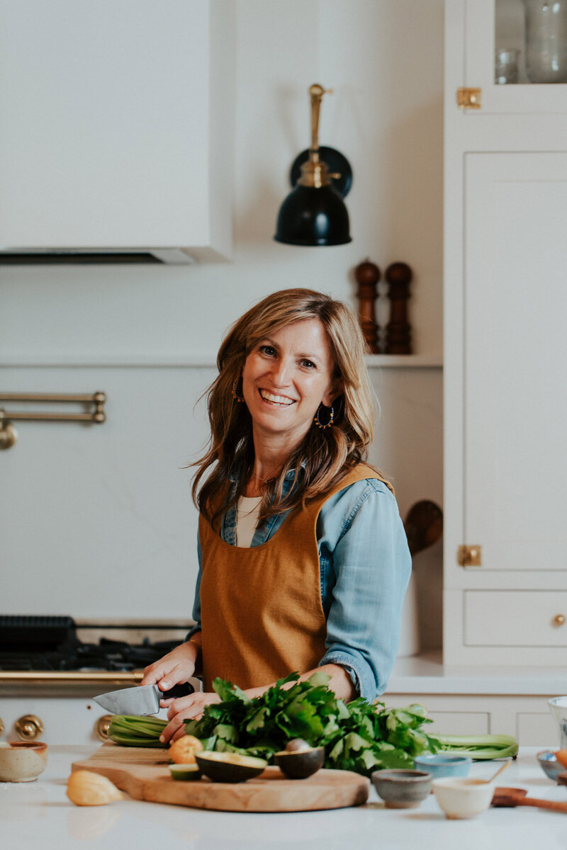 Sam smiling, chopping vegetables in her kitchen