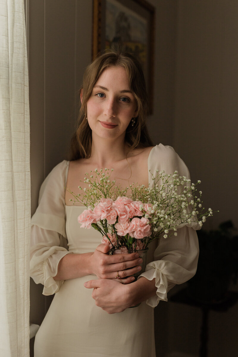 Lovely bridal portrait holding a flower vase