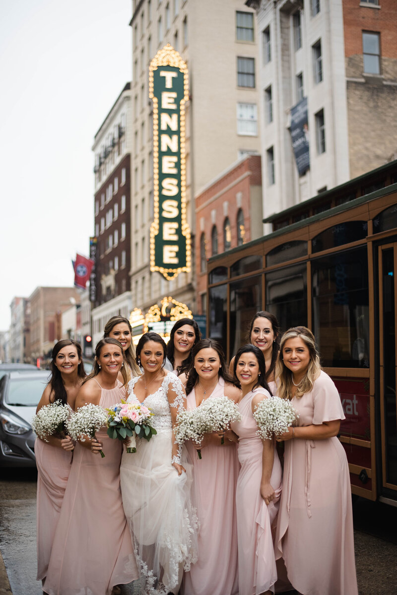 bridesmaids in pink dress in front of Tennessee sign