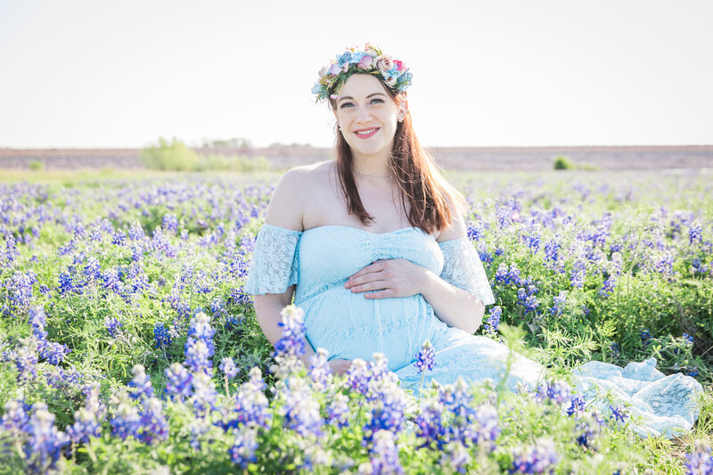 Pregnant mom in blue dress sitting in field of bluebonnets, Austin Family Photographer