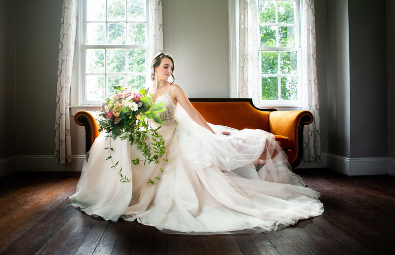 Bridal portrait of bride on orange couch, Baltimore wedding photographer