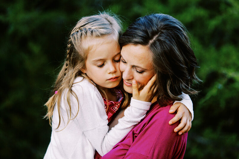 mom and daughter have a quiet moment with eyes closed