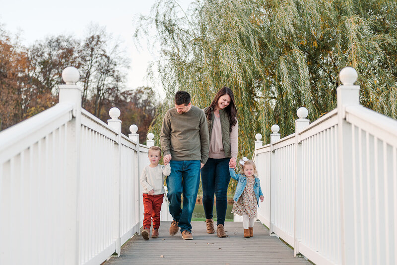 family of four walking across a white bridge at farm in harrisburg pa