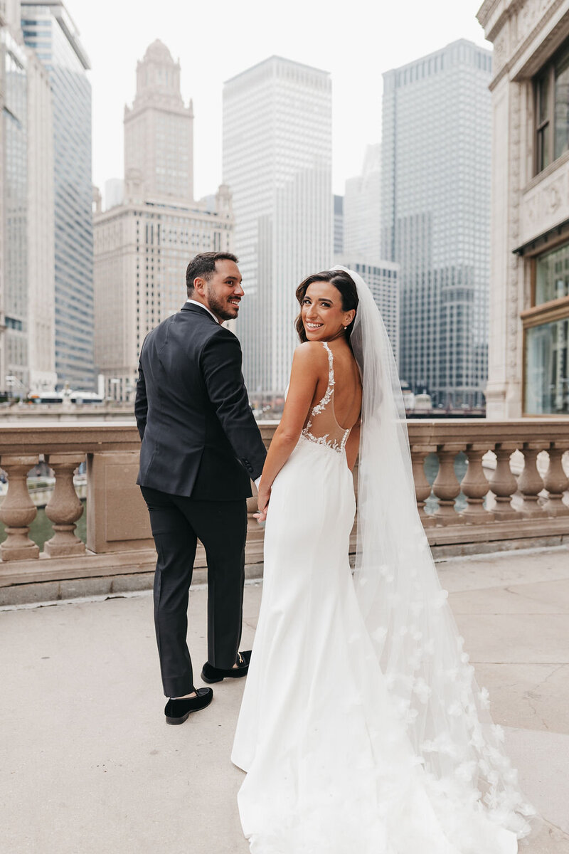 bride and groom walk holding hands 
