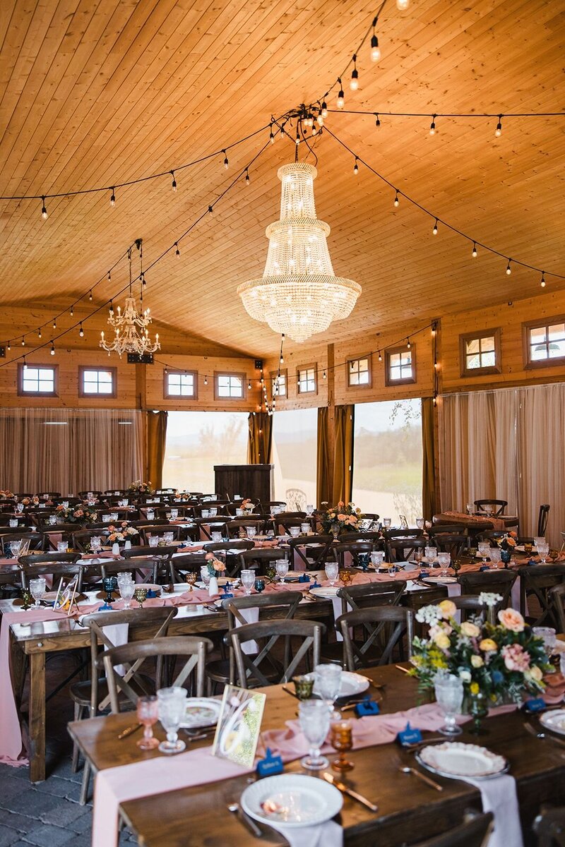 Reception space set for a wedding with vintage place settings and flower arrangements.