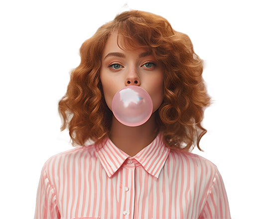 Femme rousse avec chemise bariolée rose et blanche, faisant une énorme bulle rose avec son chewing-gum.