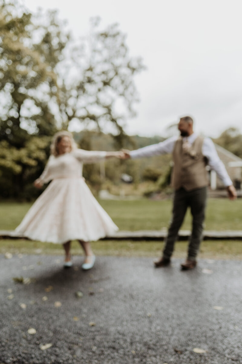 blurred colored image of bride and groom dancing in the rain