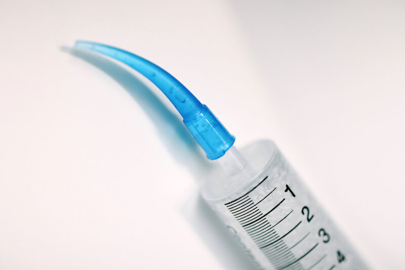 A close-up image of an injectable tooth-shaped device designed to dispense teeth whitening gel. The device resembles a tooth in shape and is filled with whitening gel, ready to be applied to the teeth. The gel is dispensed from a small opening at the tip, allowing for targeted and precise application. The tool is compact, ergonomic, and intended for professional or at-home teeth whitening treatments.