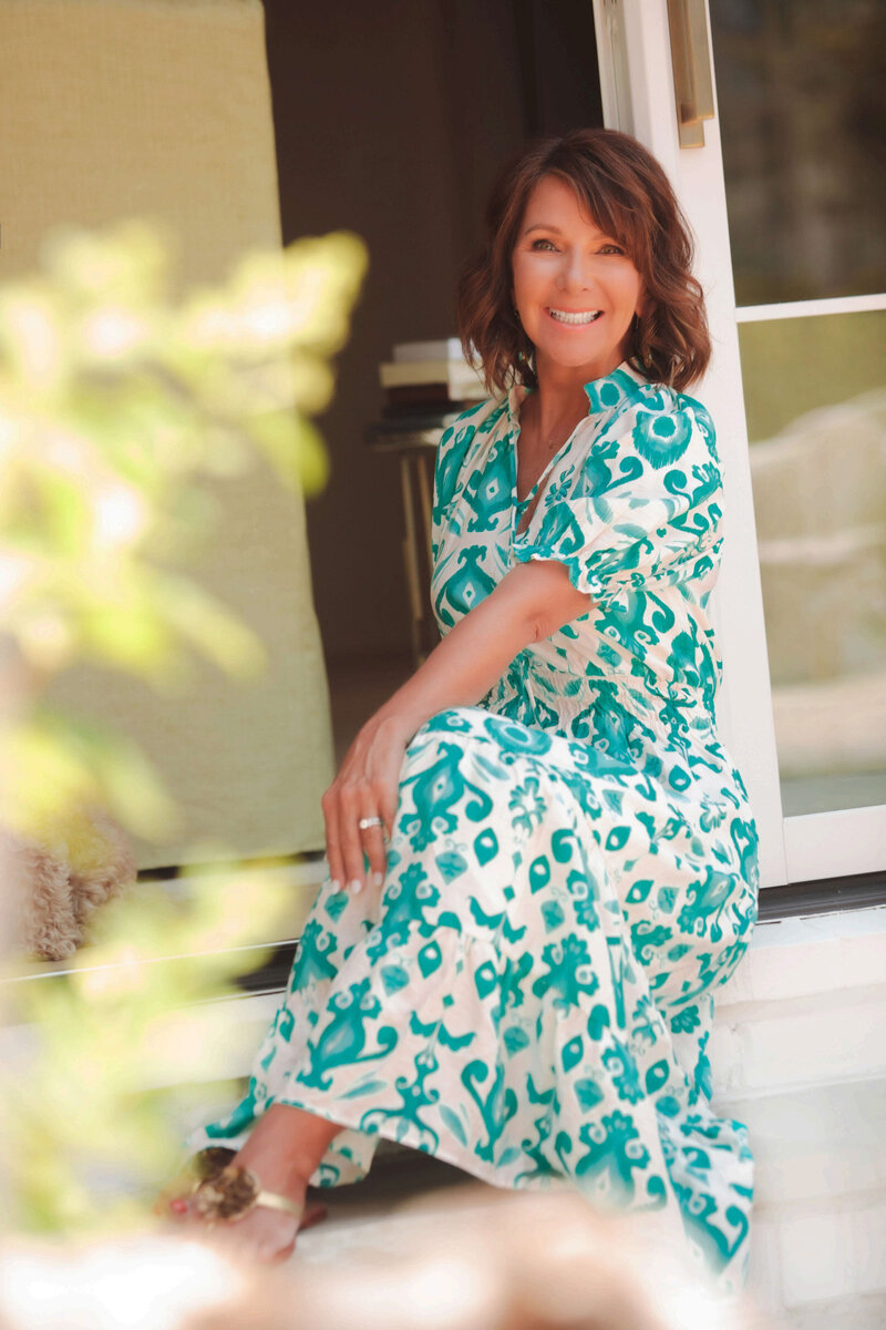 Leisa smiling in an aqua and white patterned dtess