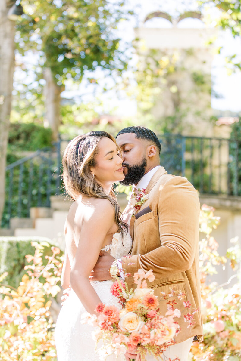 Bride and groom kiss with confetti at Stone Pine Estates in Carmel Valley