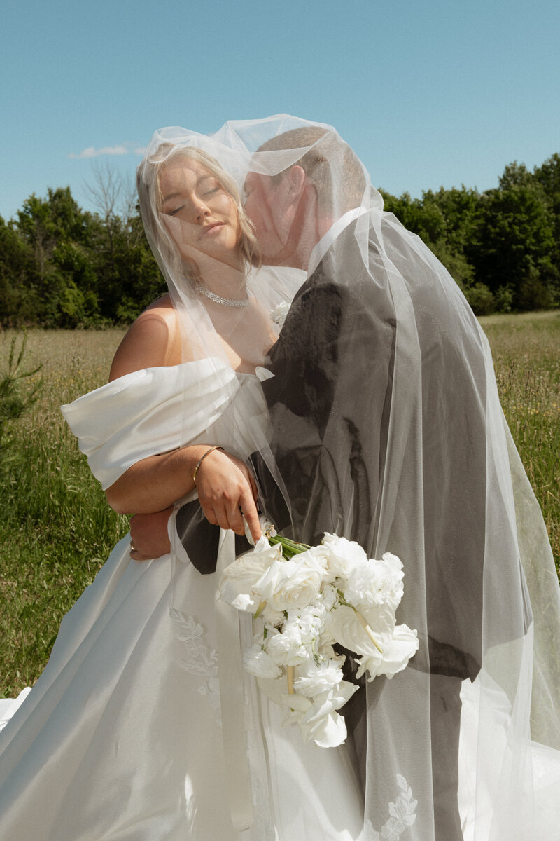 bride and groom share a romantic soft kiss after their stunning high end wedding ceremony in toronto
