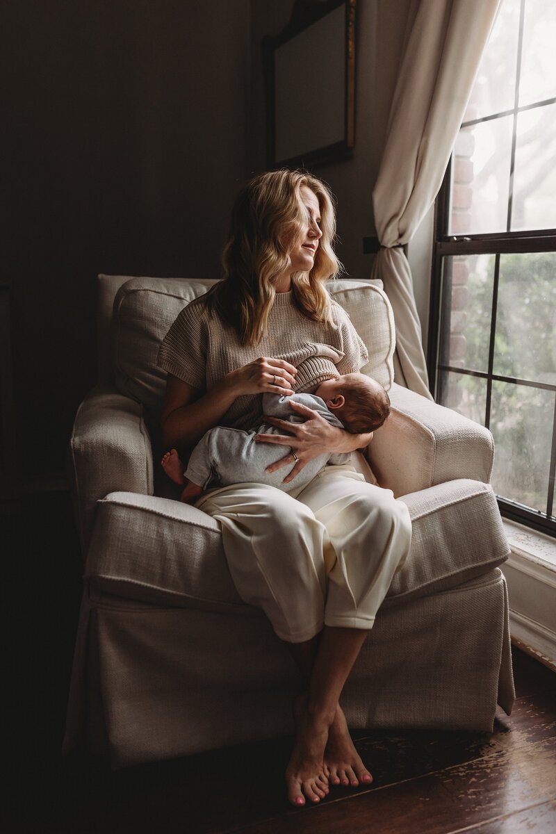 Mom breastfeeding her child sitting on an armchair