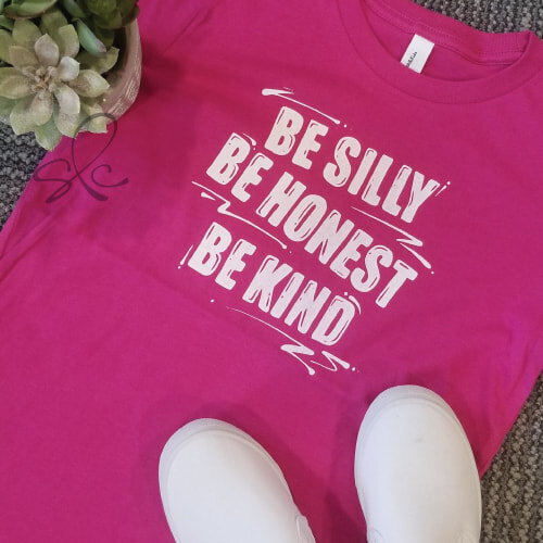 Pink t-shirt with hand lettered text "be silly, be honest, be kind"