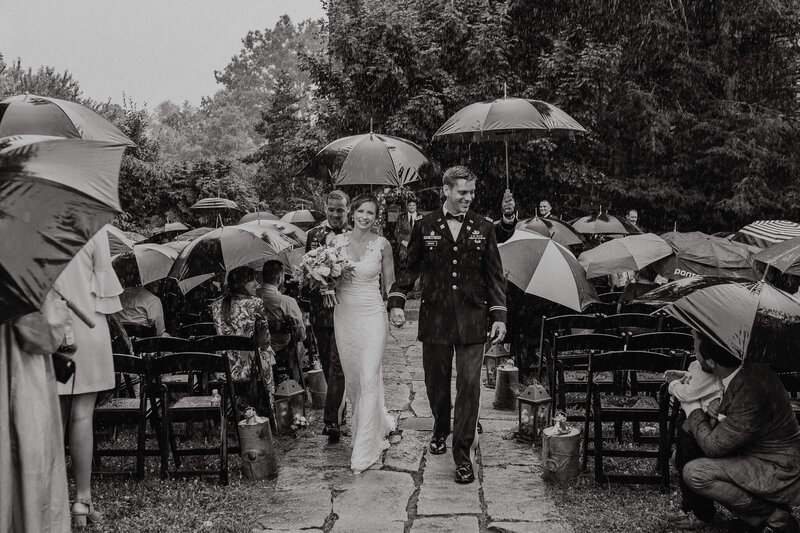 Couple smiling in the rain after their wedding ceremony.