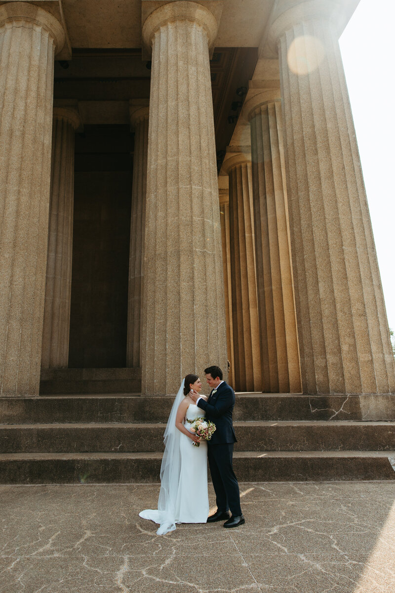 couple stands in front of parthenon in nashville